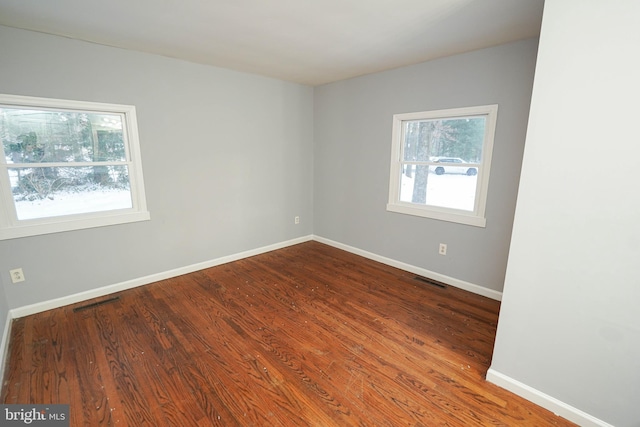 spare room featuring hardwood / wood-style floors and a wealth of natural light