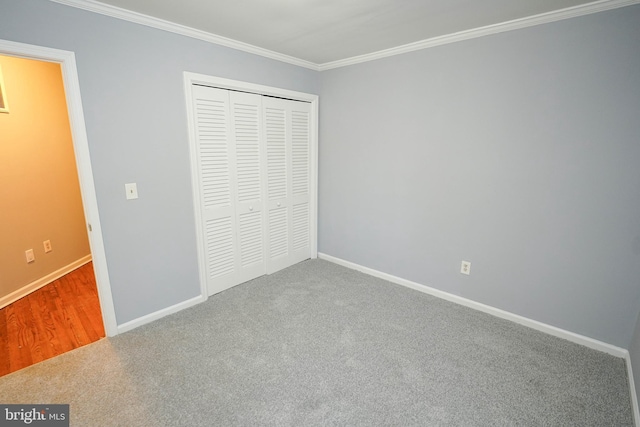 unfurnished bedroom with a closet, ornamental molding, and carpet floors