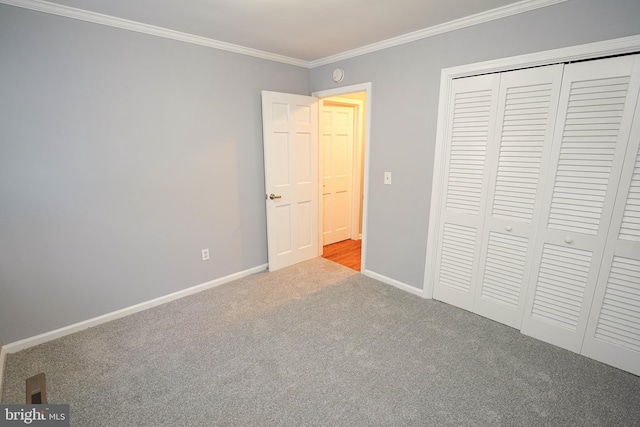 unfurnished bedroom with a closet, ornamental molding, and light colored carpet