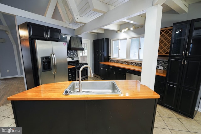 kitchen featuring stainless steel appliances, a center island with sink, butcher block countertops, and sink