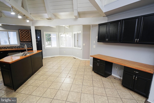 kitchen featuring wood ceiling, wooden counters, an inviting chandelier, light tile patterned flooring, and sink