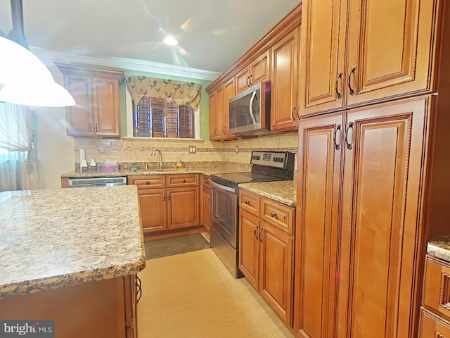 kitchen with crown molding, appliances with stainless steel finishes, hanging light fixtures, light stone counters, and tasteful backsplash