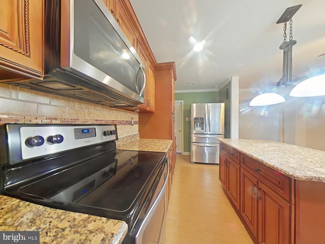 kitchen featuring appliances with stainless steel finishes, backsplash, hanging light fixtures, crown molding, and light stone countertops