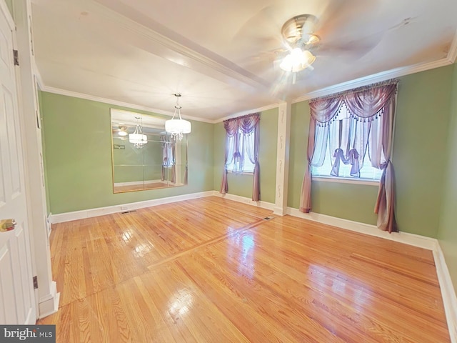 spare room featuring crown molding, ceiling fan with notable chandelier, and hardwood / wood-style floors