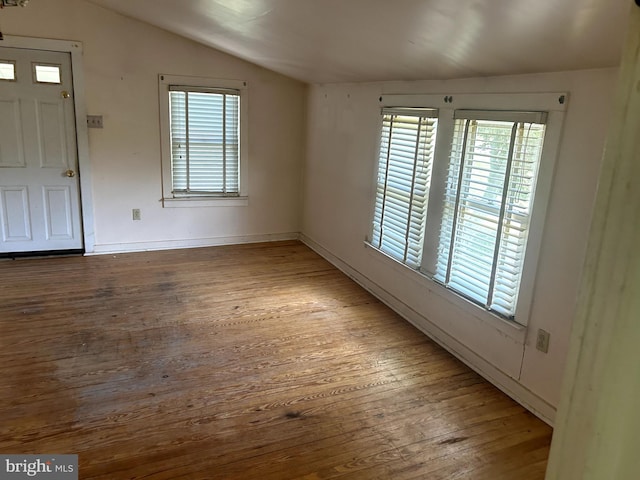 interior space with wood-type flooring, a healthy amount of sunlight, and vaulted ceiling