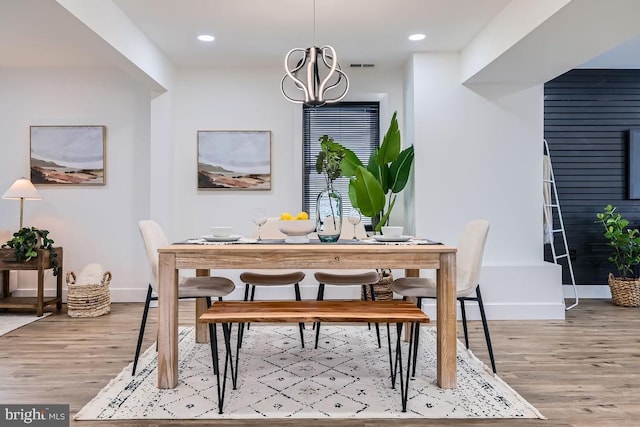 dining room with an inviting chandelier and light hardwood / wood-style flooring