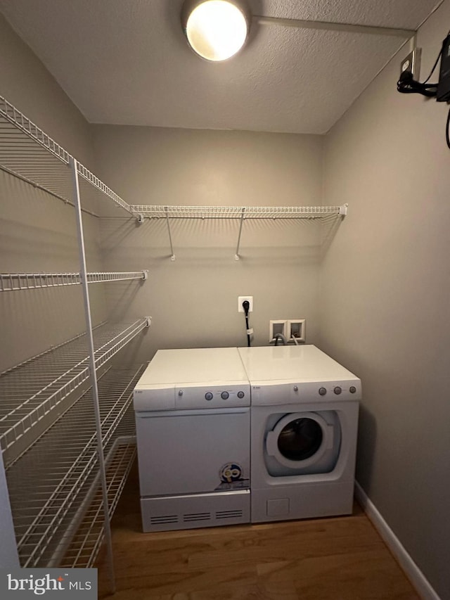 laundry room with dark hardwood / wood-style floors, a textured ceiling, and independent washer and dryer