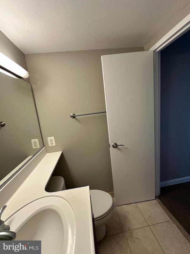 bathroom with vanity, tile patterned flooring, and toilet