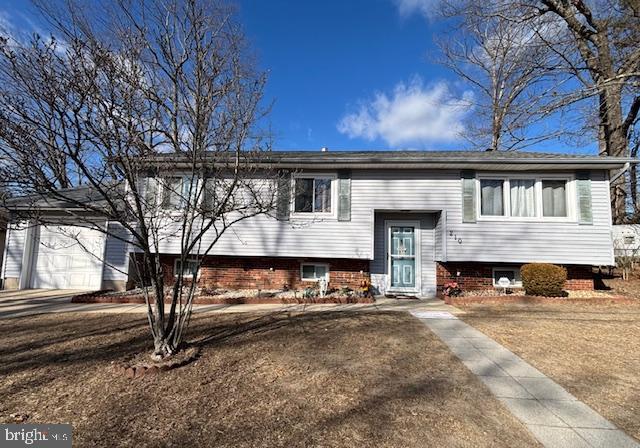 bi-level home with a garage and a front lawn