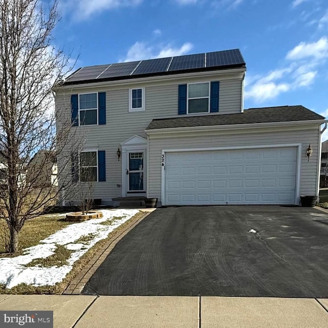 view of front facade featuring solar panels and a garage