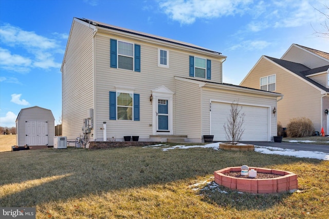 view of front of home featuring an outdoor fire pit, central AC unit, a front lawn, and a garage