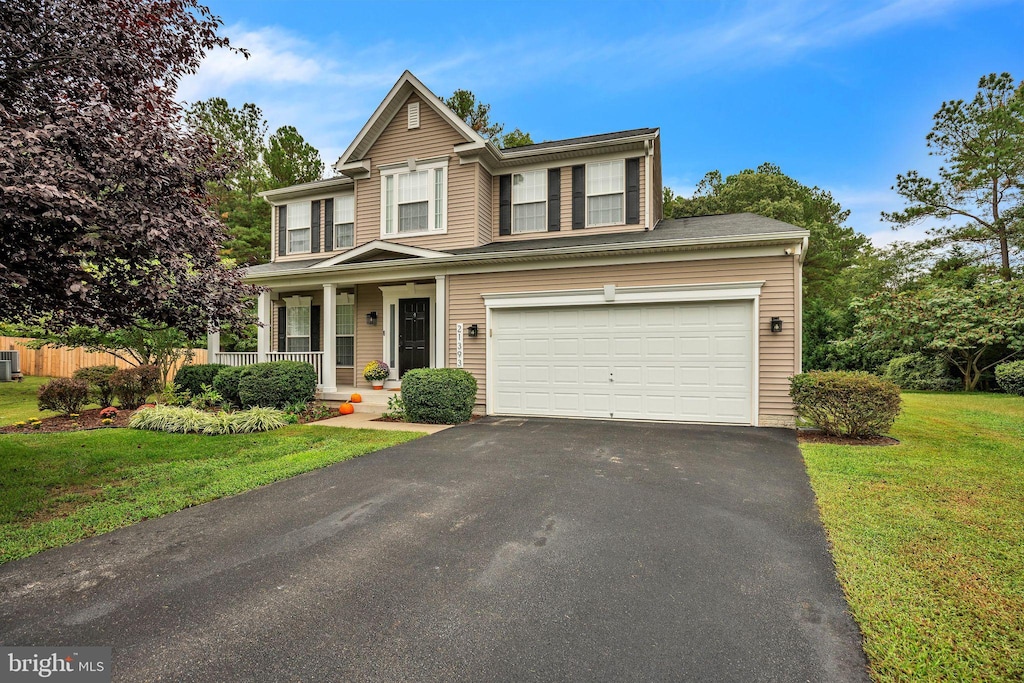 view of front of home with a garage, a porch, and a front yard