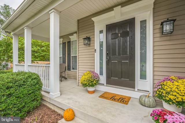 view of exterior entry featuring covered porch