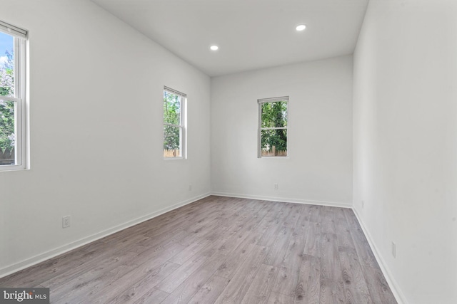 spare room with a healthy amount of sunlight and light hardwood / wood-style floors