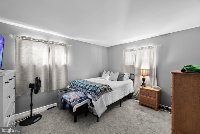 bedroom with multiple windows and light carpet