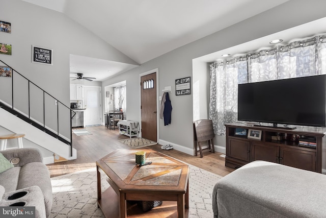 living room featuring vaulted ceiling, ceiling fan, and light wood-type flooring