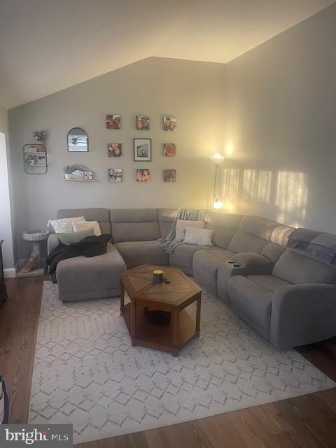 living room with lofted ceiling and hardwood / wood-style flooring