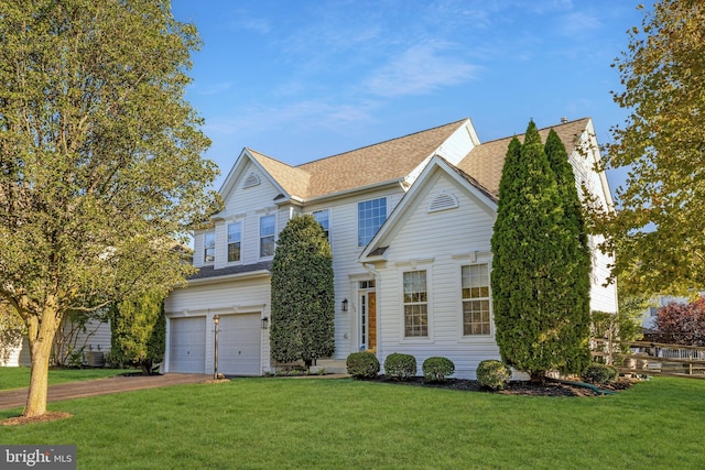 view of front of house with a garage and a front lawn