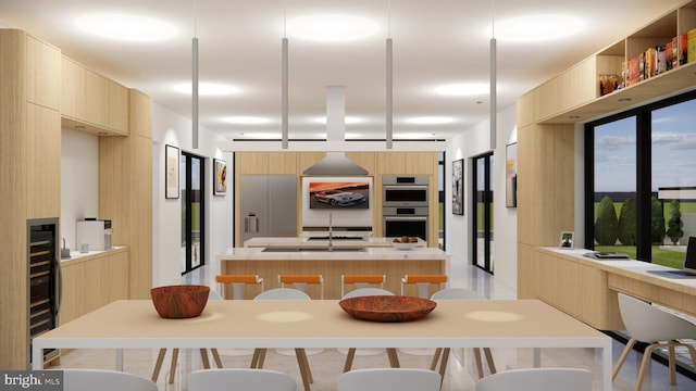 kitchen featuring double oven, a kitchen bar, a kitchen island, light brown cabinets, and sink