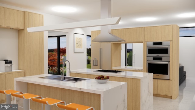 kitchen with light brown cabinetry, a center island with sink, gas stovetop, double oven, and sink