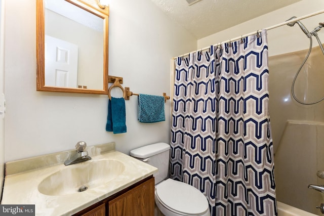 full bath with a textured ceiling, vanity, and toilet