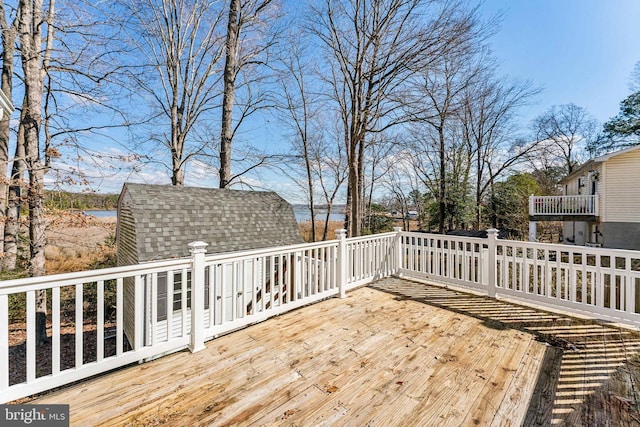 deck featuring a water view and an outbuilding