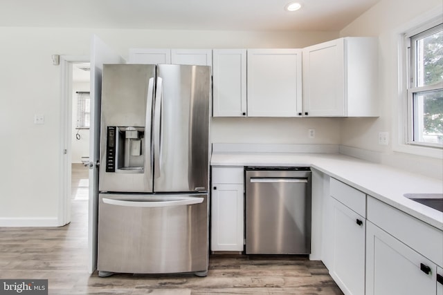 kitchen featuring light wood-type flooring, stainless steel appliances, and white cabinets