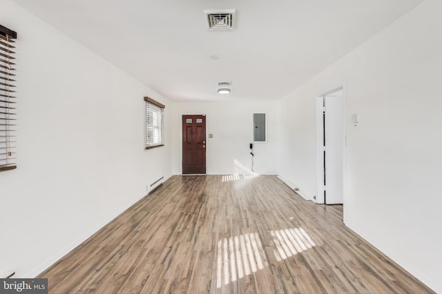 interior space featuring light hardwood / wood-style floors, a baseboard radiator, and electric panel