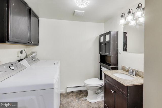 bathroom featuring toilet, vanity, a baseboard heating unit, and separate washer and dryer