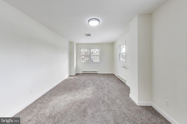 carpeted spare room featuring baseboard heating