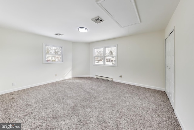 empty room featuring plenty of natural light, carpet, and a baseboard heating unit