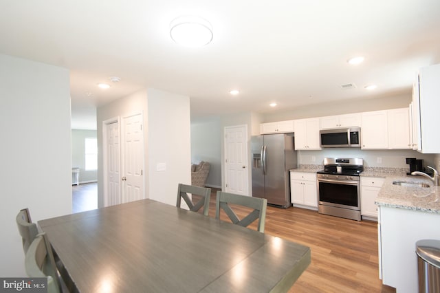 dining space with sink and light hardwood / wood-style floors