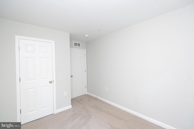 unfurnished bedroom featuring light carpet