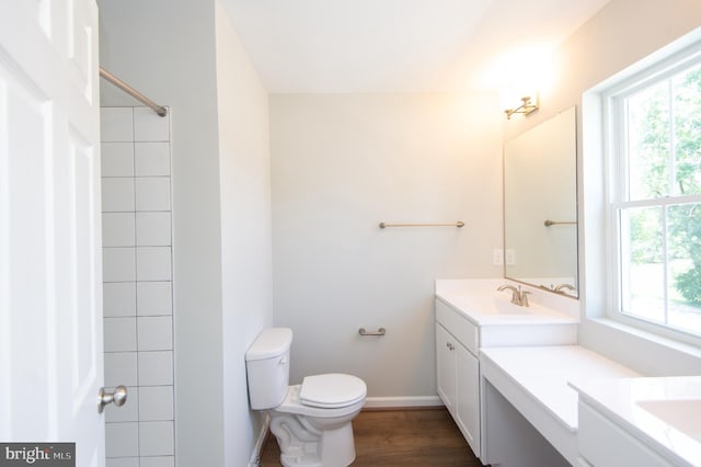 bathroom featuring a healthy amount of sunlight, hardwood / wood-style flooring, vanity, and toilet