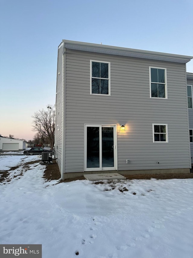 snow covered house with central air condition unit