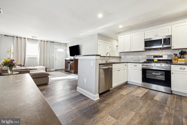 kitchen featuring sink, appliances with stainless steel finishes, dark hardwood / wood-style flooring, and white cabinetry