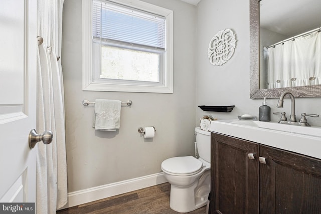 bathroom featuring toilet, hardwood / wood-style flooring, and vanity