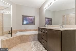 bathroom featuring vanity, tile patterned floors, and tiled bath