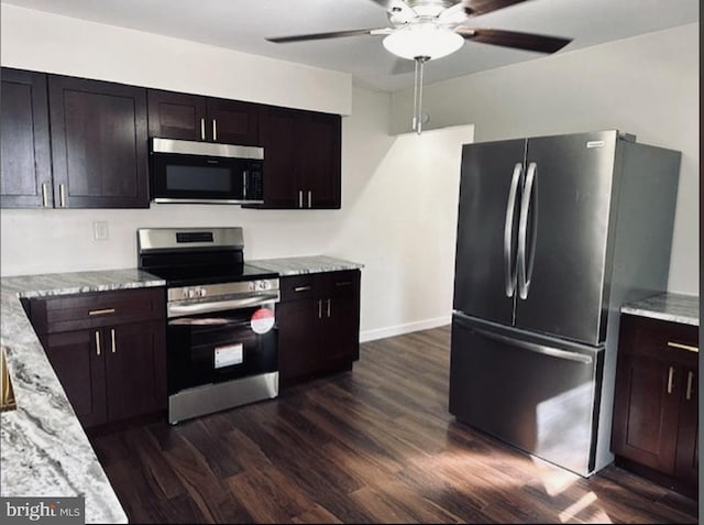 kitchen featuring light stone counters, dark hardwood / wood-style floors, stainless steel appliances, ceiling fan, and dark brown cabinets