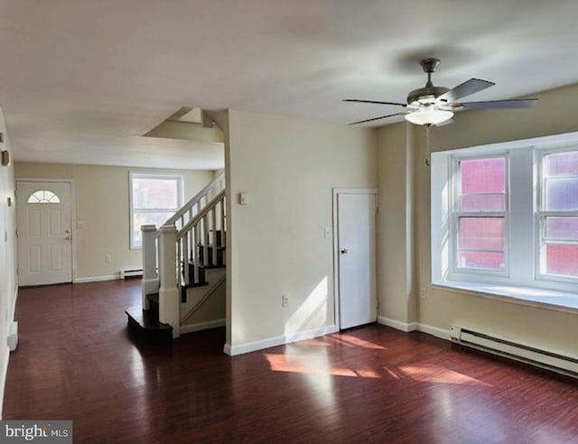 foyer entrance with baseboard heating, ceiling fan, and dark wood-type flooring