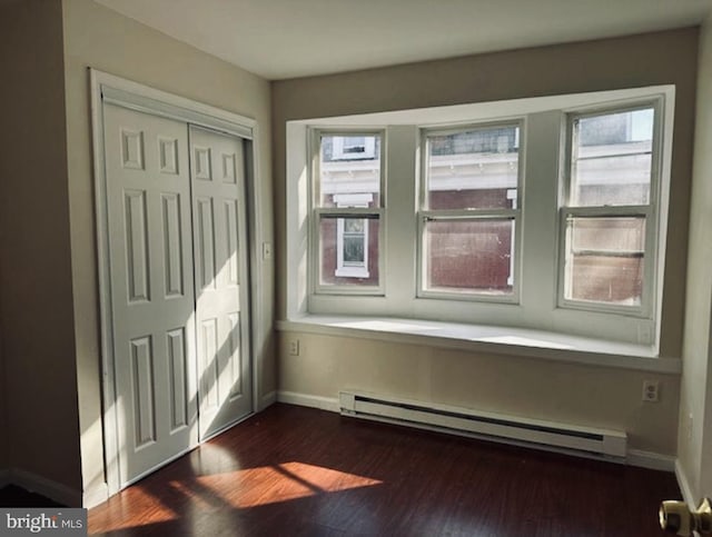 entrance foyer featuring dark hardwood / wood-style flooring and a baseboard heating unit