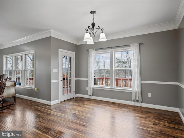 dining space with dark wood-type flooring, a chandelier, and crown molding