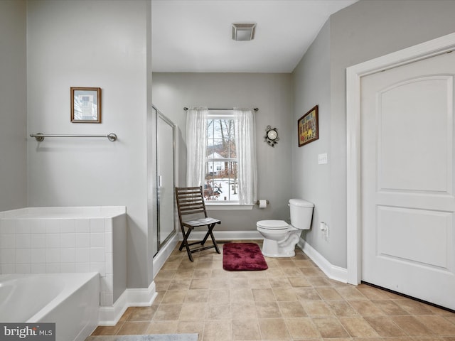 bathroom featuring toilet, tile patterned flooring, and separate shower and tub