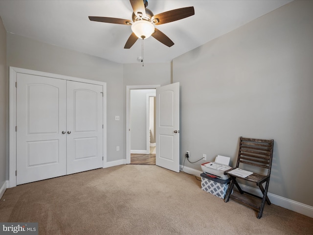 interior space featuring ceiling fan, a closet, and light colored carpet