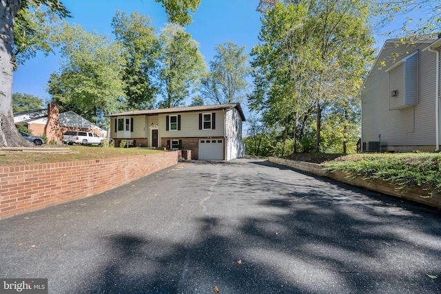 bi-level home with central air condition unit and a garage