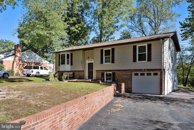 split foyer home featuring a front lawn and a garage