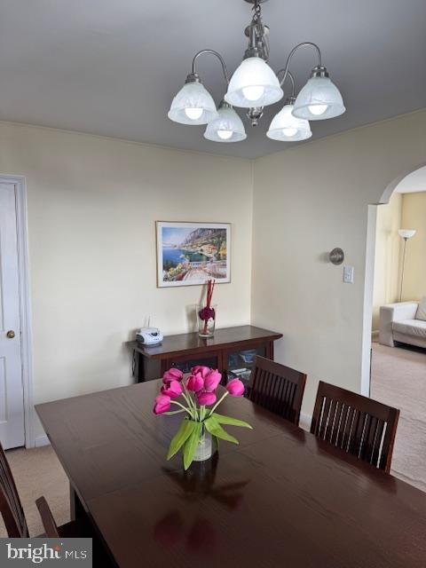 dining room featuring an inviting chandelier and light colored carpet