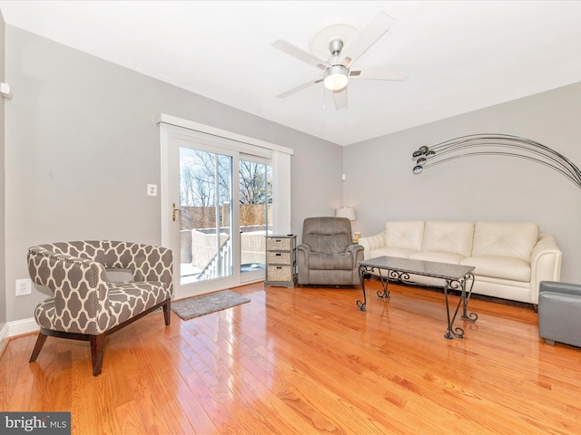 living room featuring wood-type flooring and ceiling fan