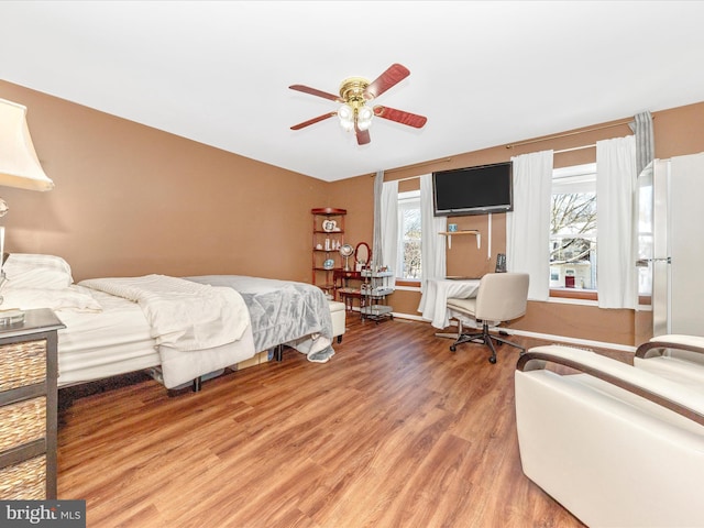 bedroom featuring ceiling fan, hardwood / wood-style floors, and white fridge