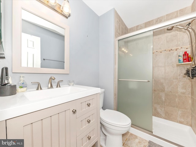 bathroom with tile patterned floors, vanity, toilet, and an enclosed shower